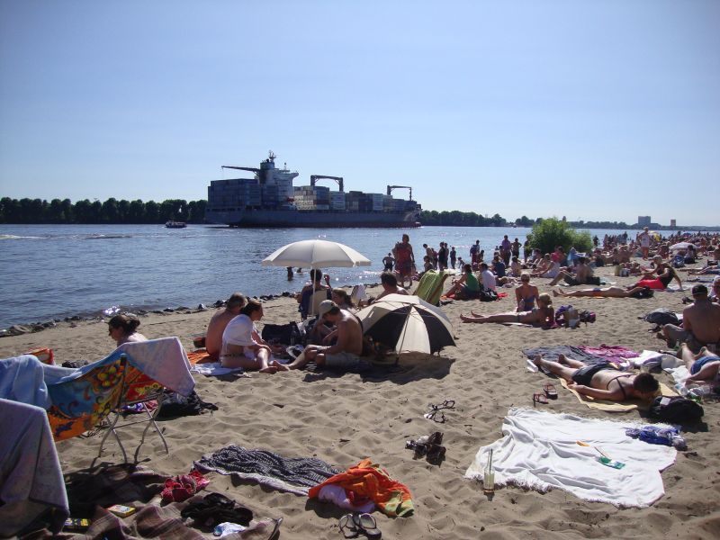 Strand an der Elbe, Schiff fährt vorbei. Im Hintergrund Elbinseln